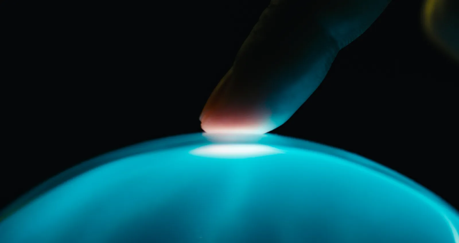 foto de un dedo tocando una burbuja azul