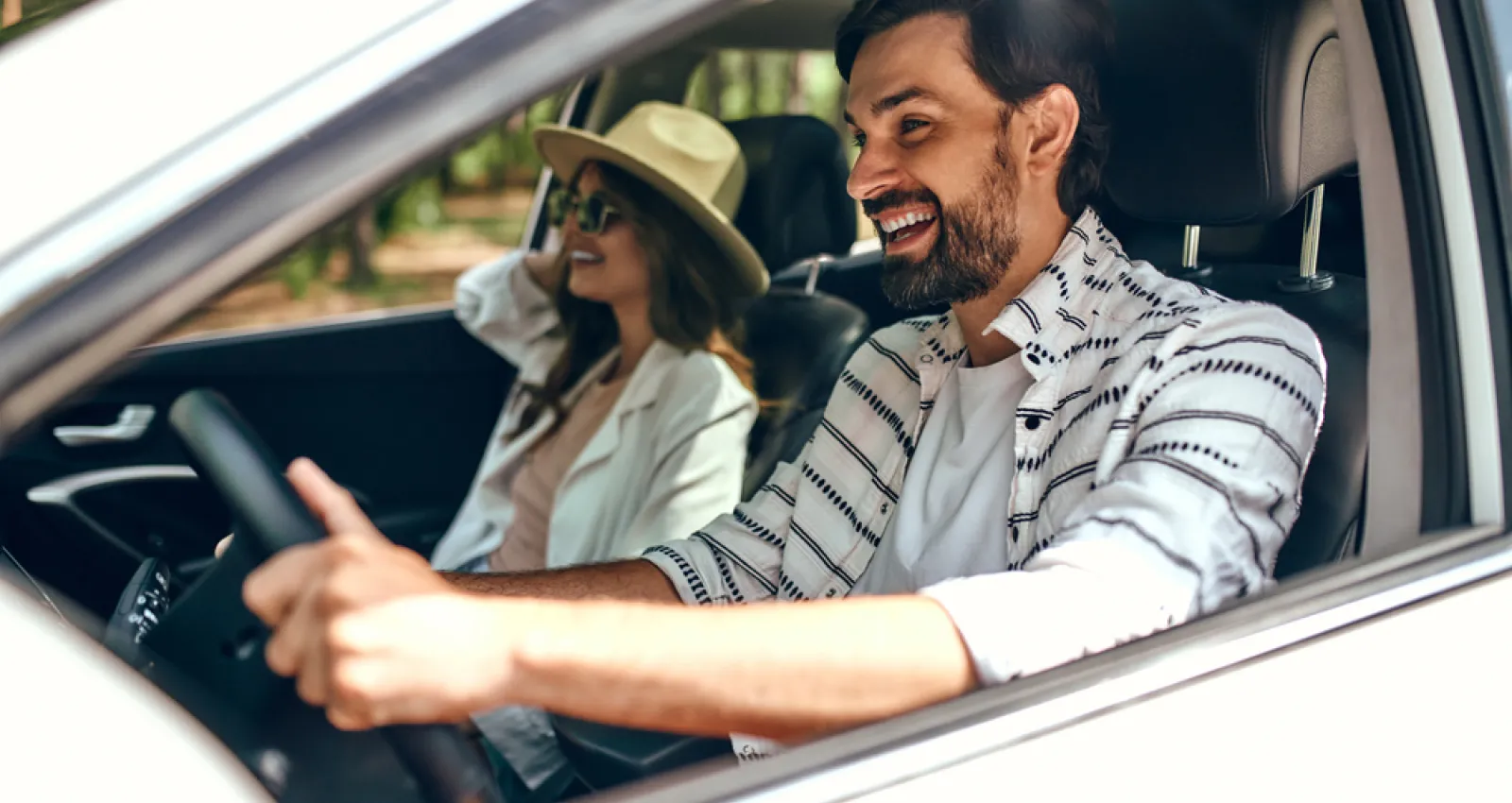 foto de un hombre manejando un carro con una mujer a su lado