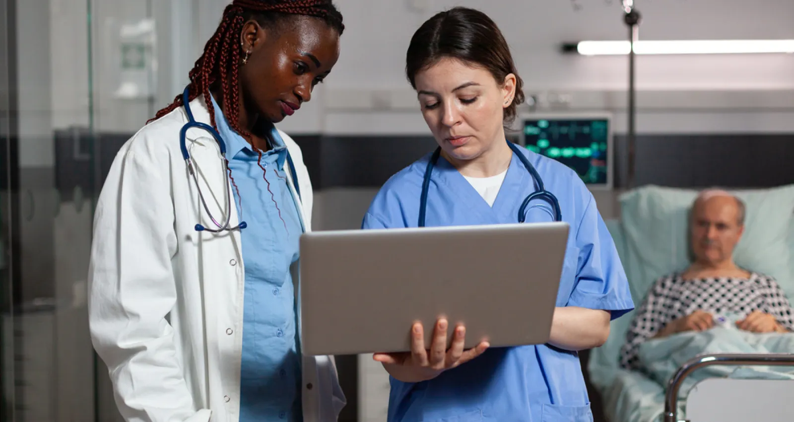 foto de un hombre y una mujer mirando un computador en una sala médica