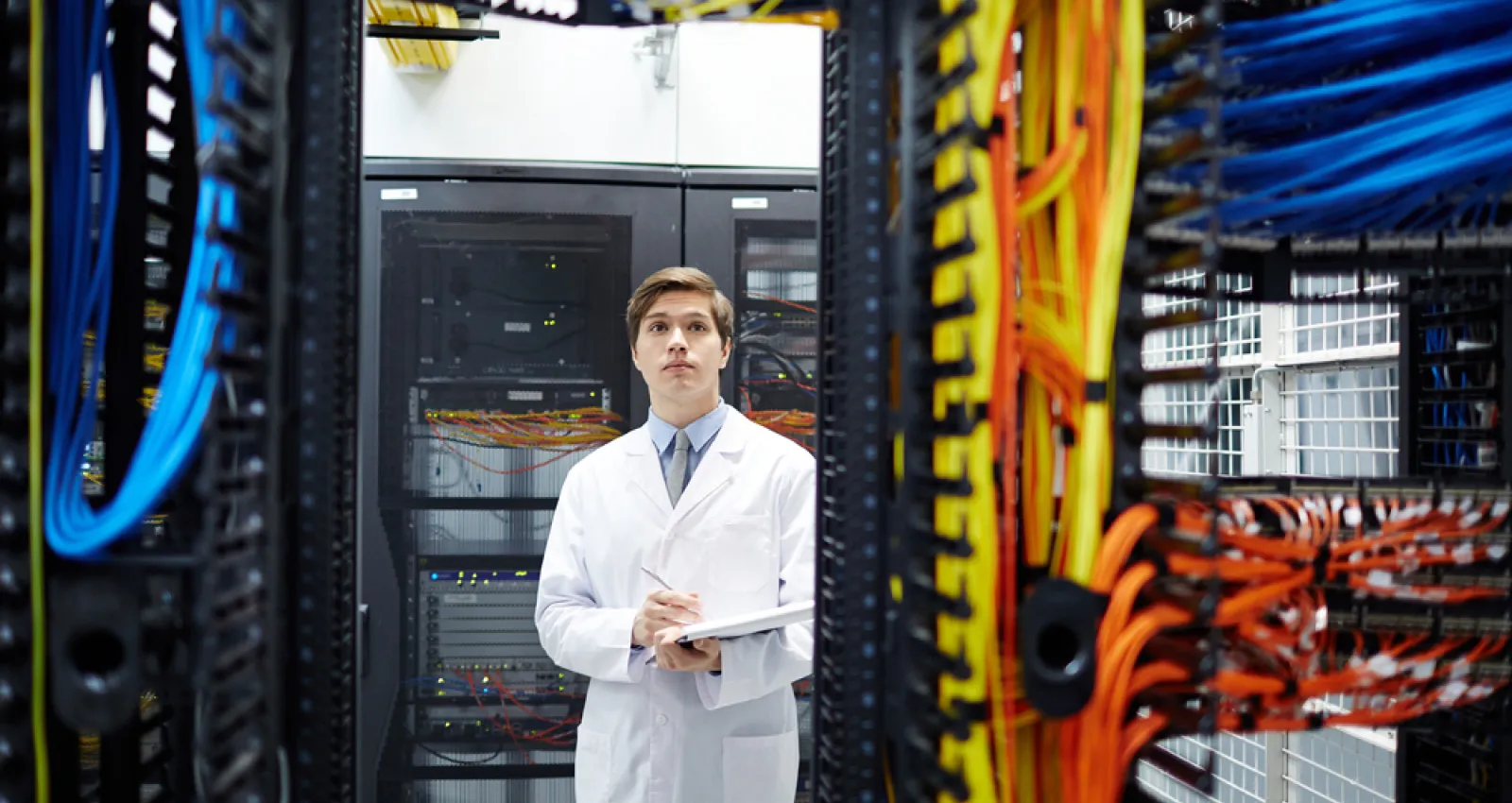 foto de un señor con bata frente a un computador grande