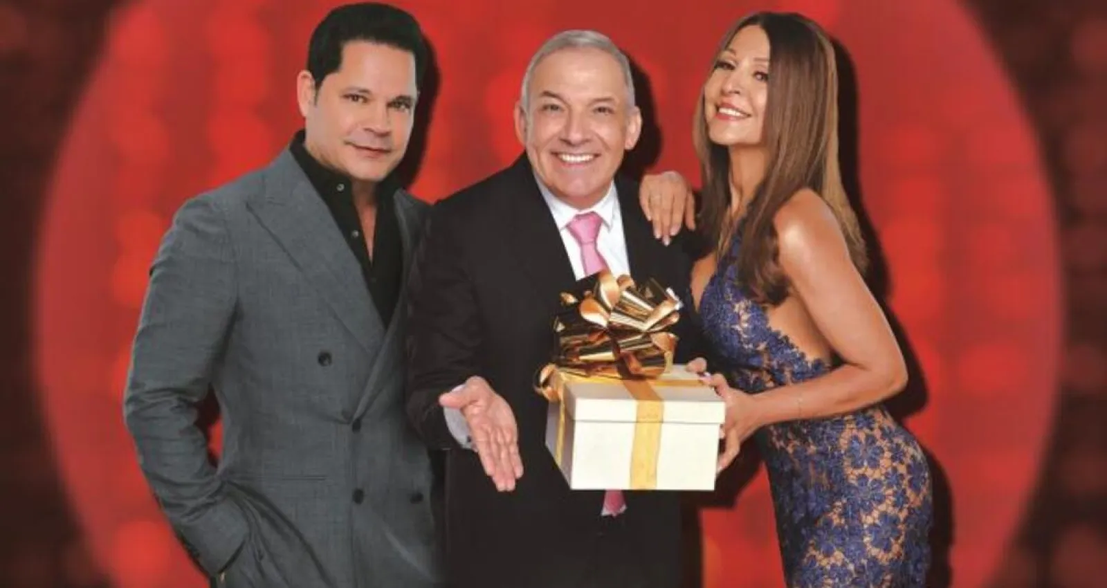 foto de una mujer y dos hombres posando con un regalo en sus manos