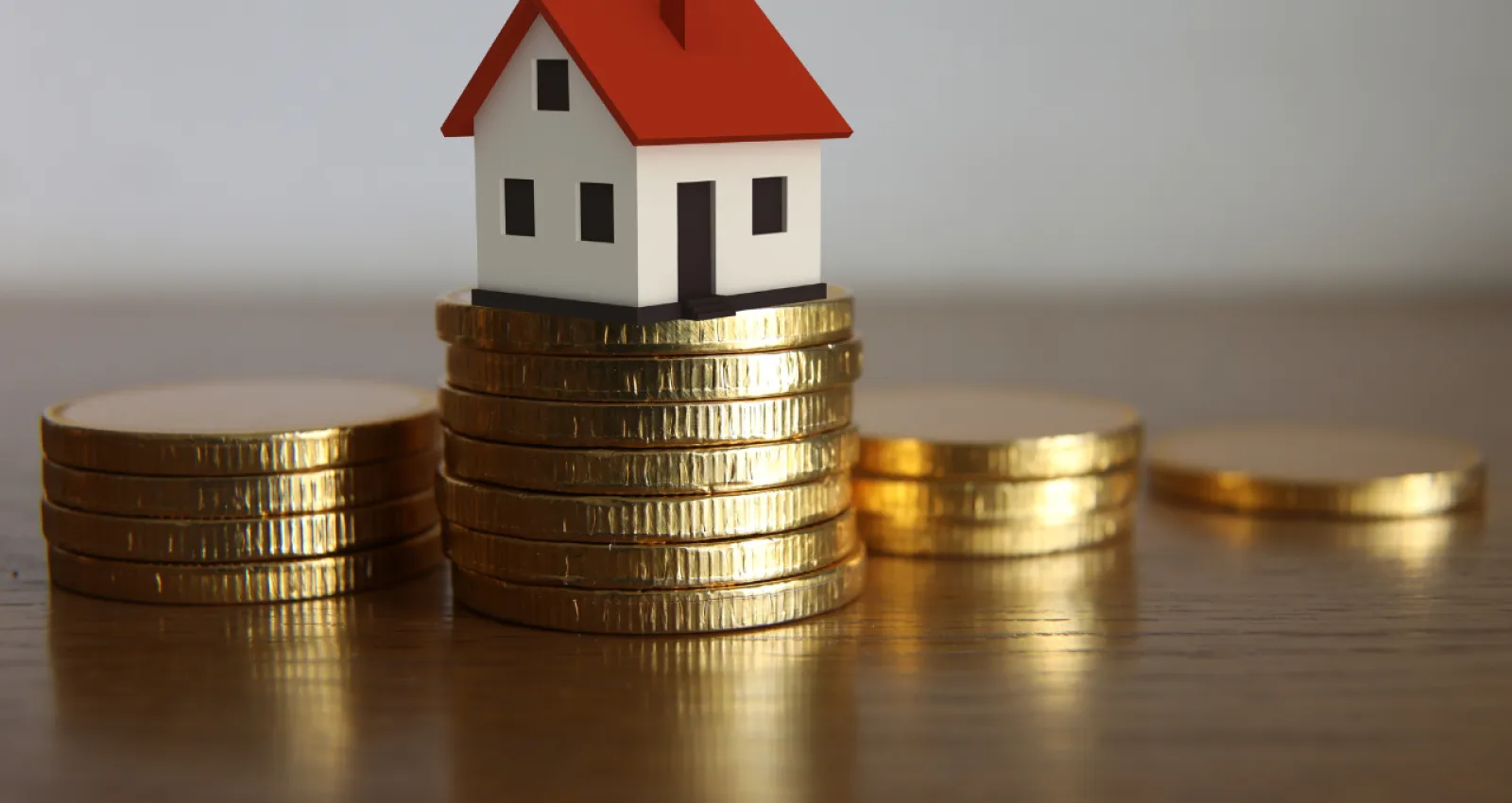 monedas y una casa pequeña