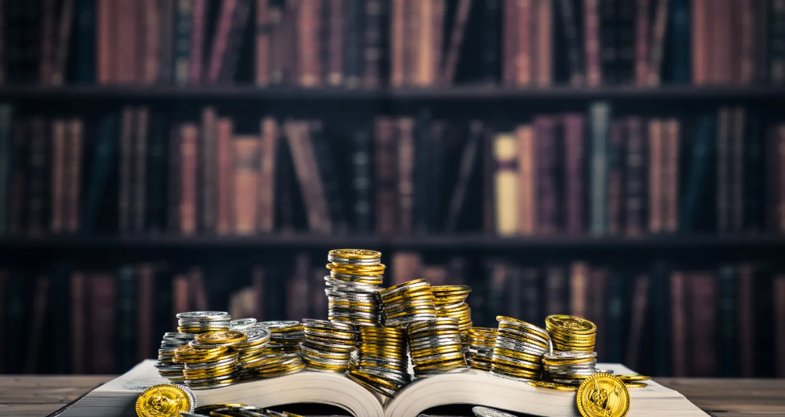 Libro abierto con monedas encima haciendo alusión a los libros de finanzas e inversiones