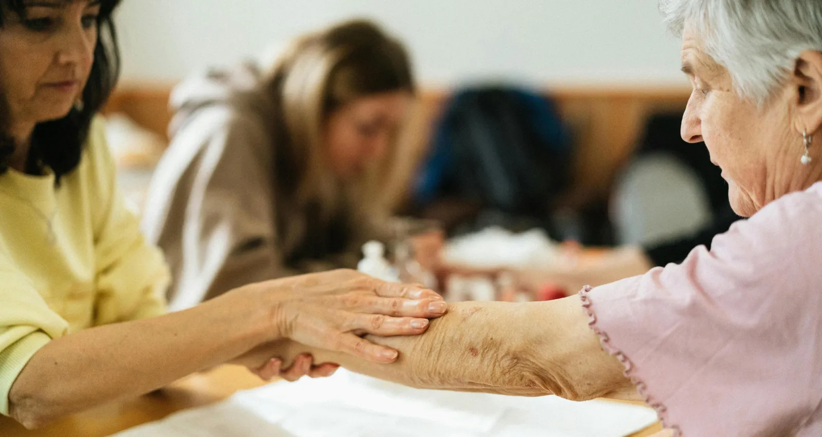 una persona haciendole masajes a una persona mayor