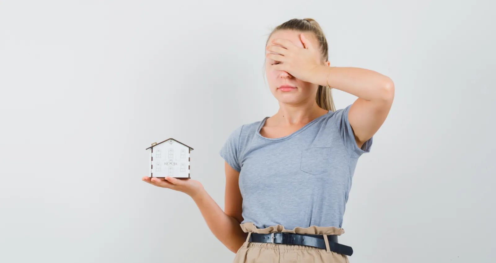 fotografía de una mujer sosteniendo un reloj y tapandose el rostro