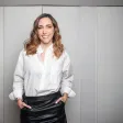 Mujer blanca con pelo castaño mirando a la cámara