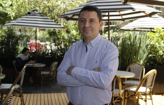 Foto de un hombre cruzado de brasos mirando a la cámara