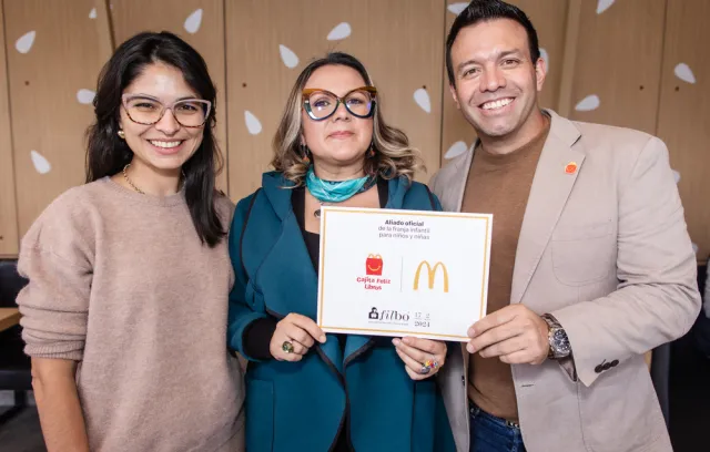 Foto de tres personas, dos mujeres y un hombre posando para la cámara
