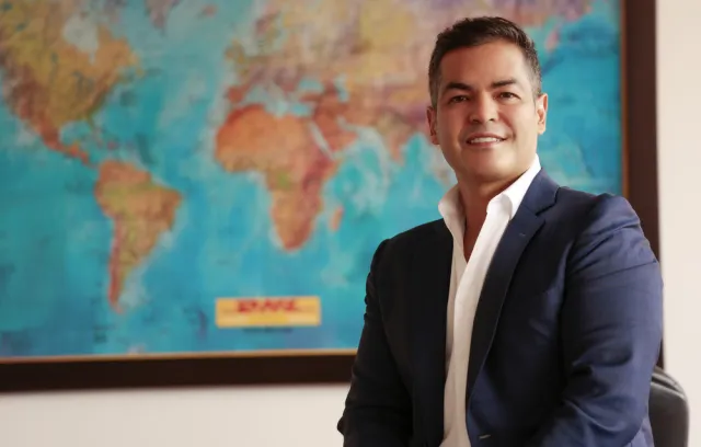 foto de un señor sonriendo a la cámara con un mapa de fondo