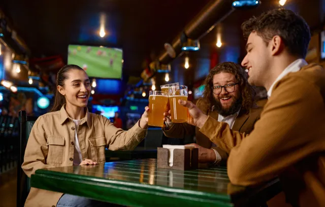 Amigos mirando un partido de futbol y tomando cerveza