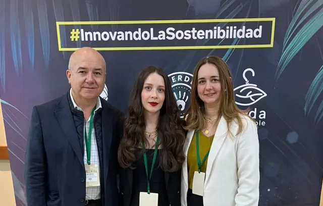 Foto de un hombre y dos mujeres a su lado mirando al lente