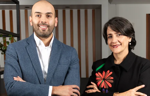 Foto de un hombre y una mujer posando frente a la cámara