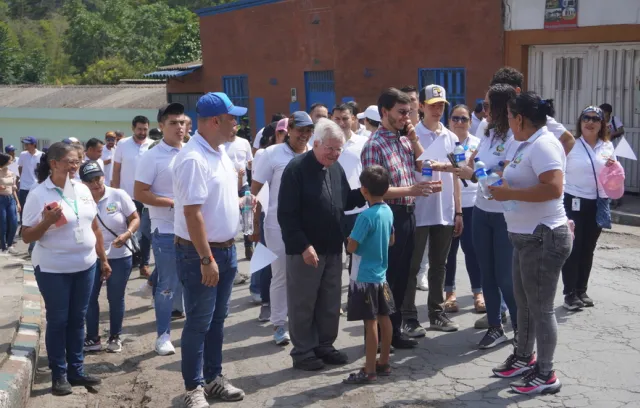 Foto de un cura con comunidad alrededor