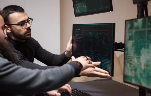 Foto de dos personas mirando una pantalla