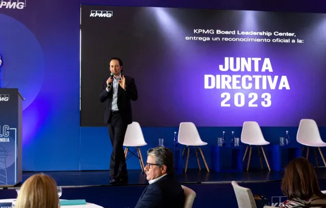 Foto de una persona presentando un tema a varios conferencistas