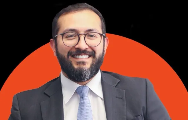 carlos alberto suarez , foto de un señor mirando a la cámara con un fondo naranja y negro