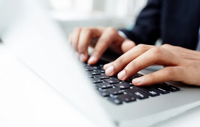 Imagen de una persona tecleando en un computador portatil