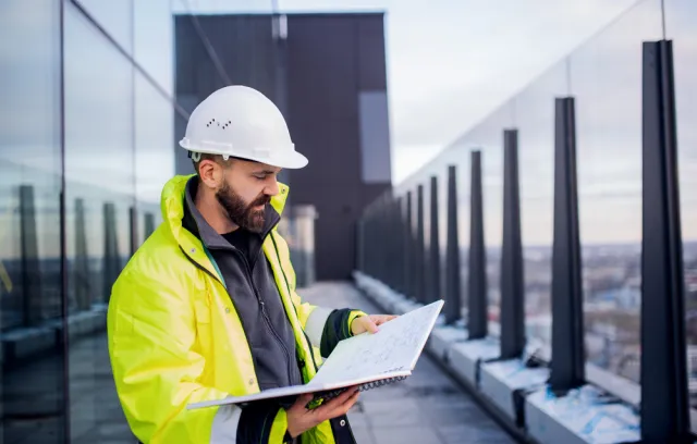 Constructor mirando planos en una terraza