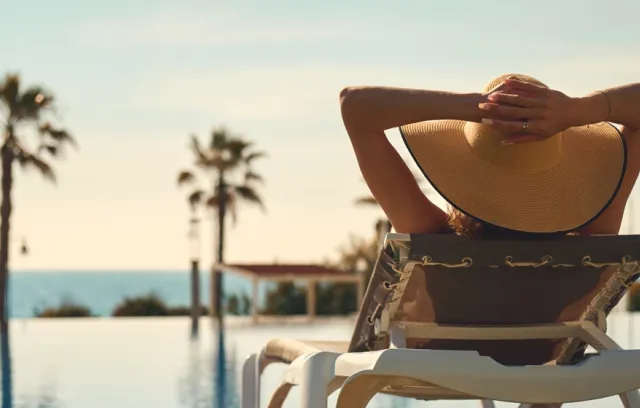 Foto de una mujer de espaldas mirando la playa