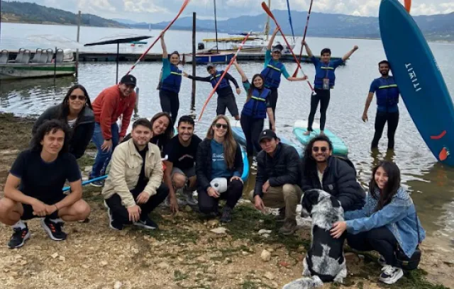 Foto devarias personas reunidas y mirando a la cámara con un lago de fondo