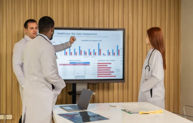 Doctores hablando sobre un televisar con gráficas