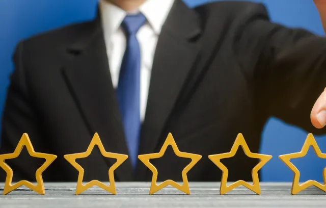 Una persona señalando cinco estrellas que están sobre una mesa