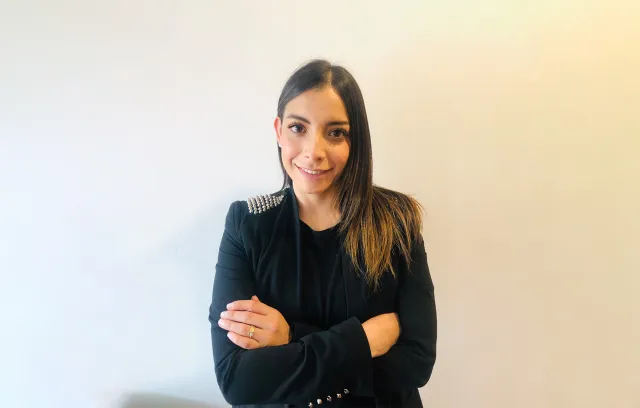 Foto de una mujer con blazer negro mirando a la cámara