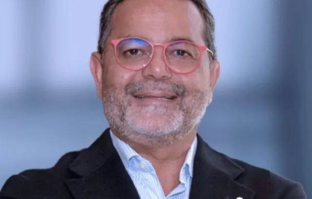 Foto de un profesional con gafas rojas mirando a la cámara