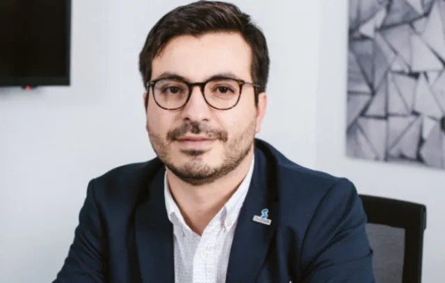 Okar Sarquis, foto de un hombre con traje y gafas mirando a la cámara