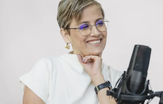 Foto de Patricia Velásquez, una mujer sonriente con un micrófono de frente