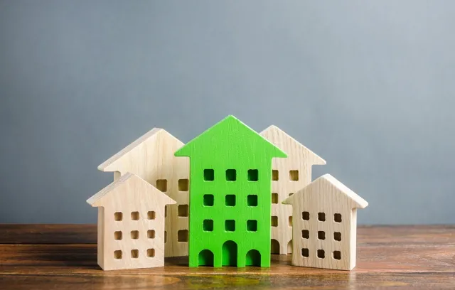 Foto de cinco casas de madera y una de ellas está pintada de verde