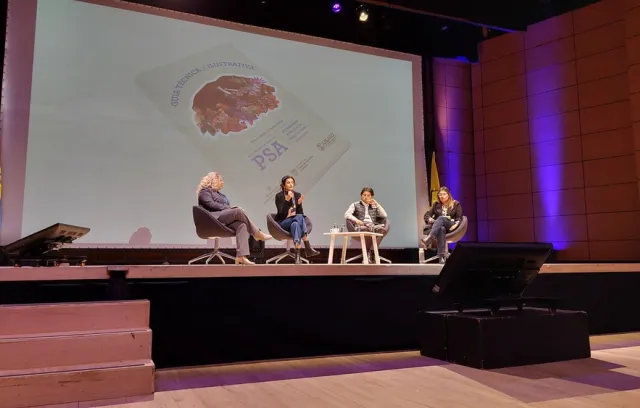 Foto de cuatro mujeres sentadas frente a un panel