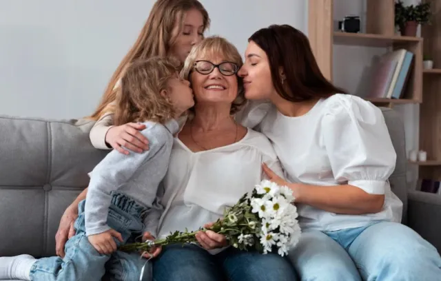 Foto de dos hijas besajndo a su mamá en la mejilla