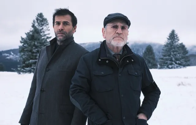 Foto de dos hombres con chaquetas y nieve de fondo