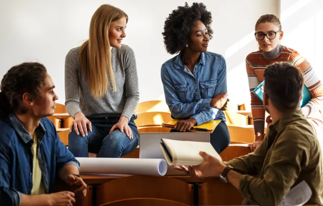 Foto de estudiantes hablando en un salon de clases 