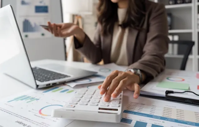 Foto de la mano de una mujer cuadrando las finanzas de una compañía