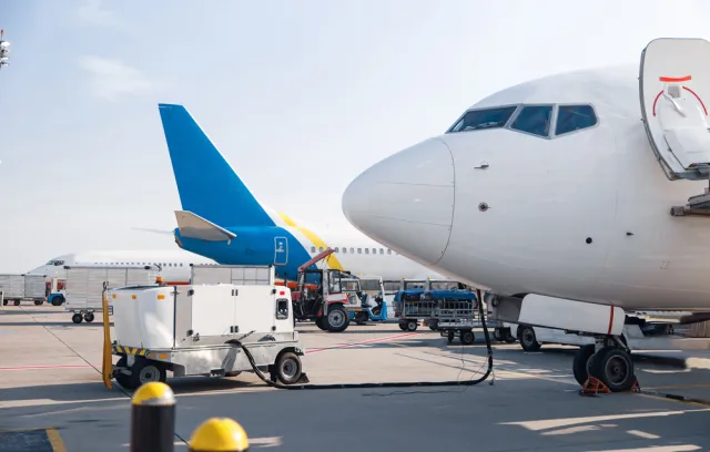 Foto de la parte delantera de un avión estacionado con otros de fondo