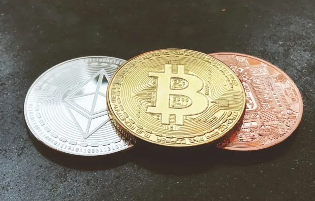 Foto de tres criptomonedas de diferente color