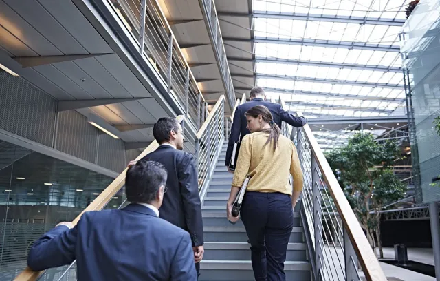 Foto de tres personas subiendo una escalera