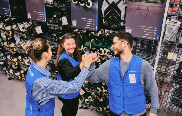 Foto de tres trabajadores de decathlon juntando sus manos