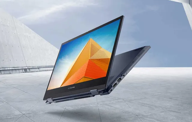 Foto de un computador con la pantalla entreabierta con un fondo gris
