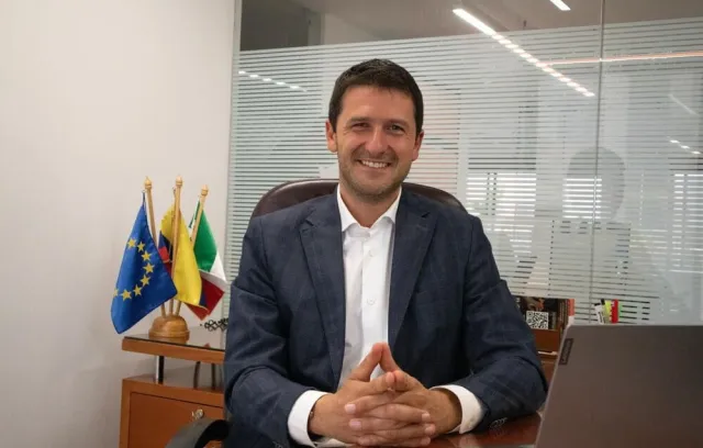 Foto de un dilomático jóven sentado mirando a la cámara