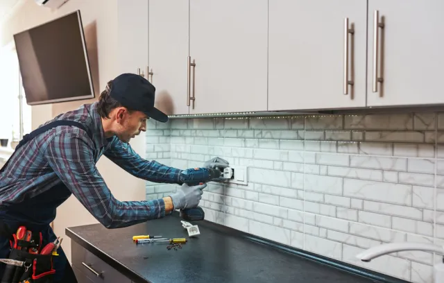 Foto de un electricista instalando un toma corriente
