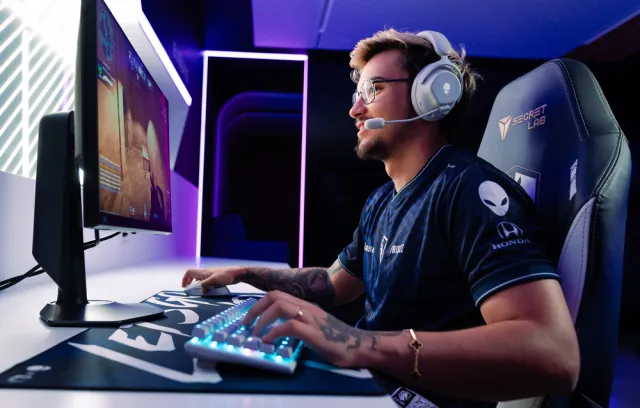 Foto de un gamer jugando sobre una computadora con luces de colores