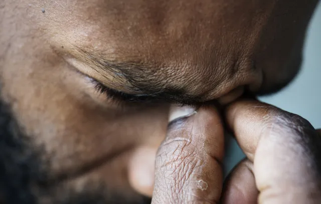 Foto de un hombre cogiendose los ojos, seña de que está estresado
