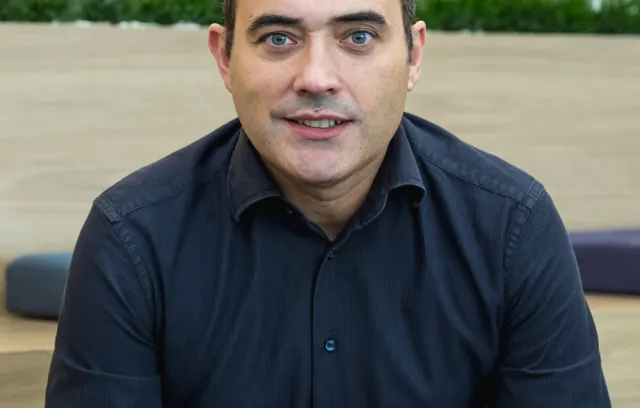 Foto de un hombre con camiseta azul mirando a la cámara