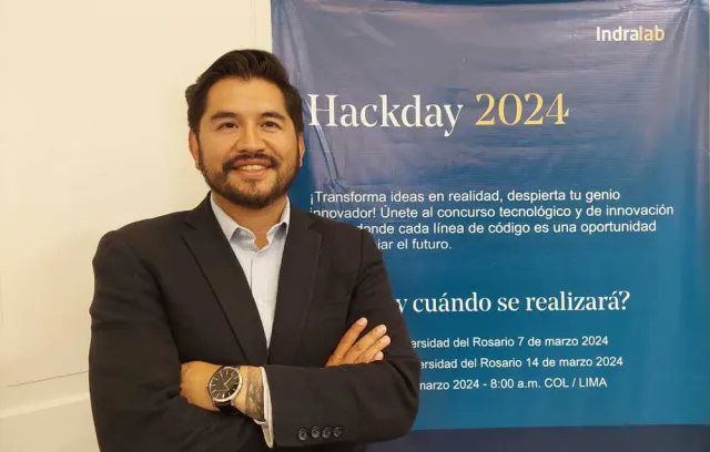Foto de un hombre con elo negro y blazer mirando a la cámara