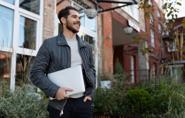 Foto de un hombre con un computador en su mano