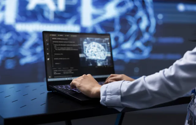 Foto de un hombre escribiendo sobre un computador, cintel