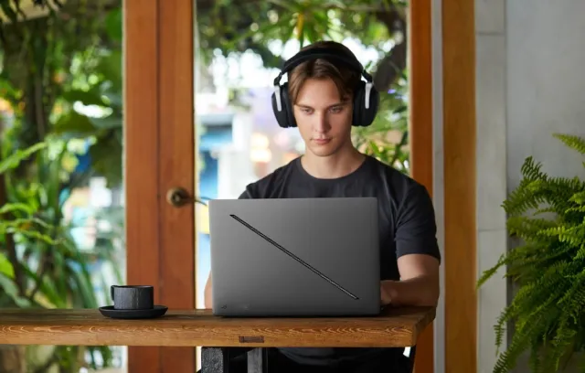 Foto de un hombre jóven y serio mirando un computador de Asus